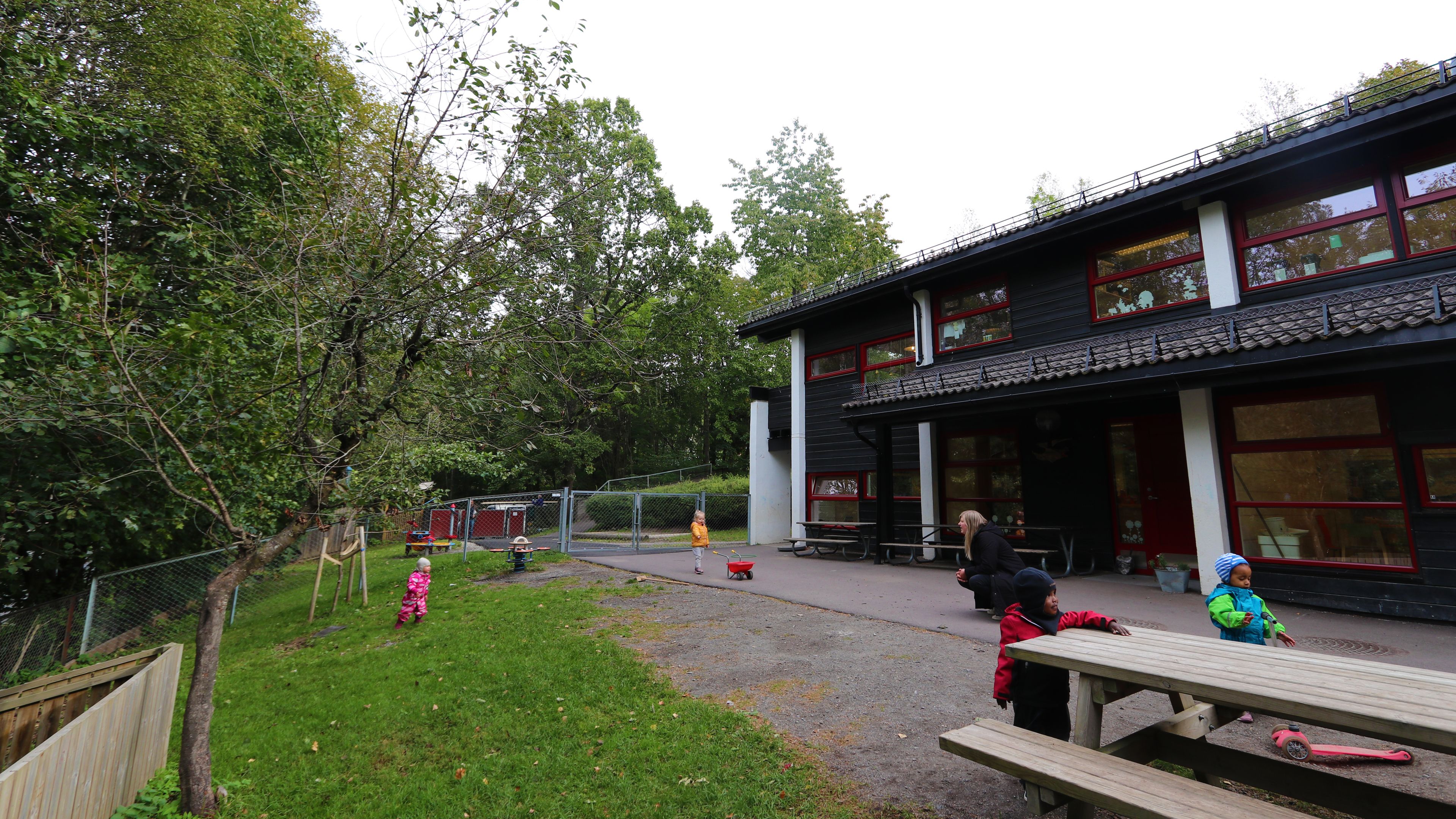 Tre barn som går rundt på lekeplass foran Frydenhaug SiO Barnehage