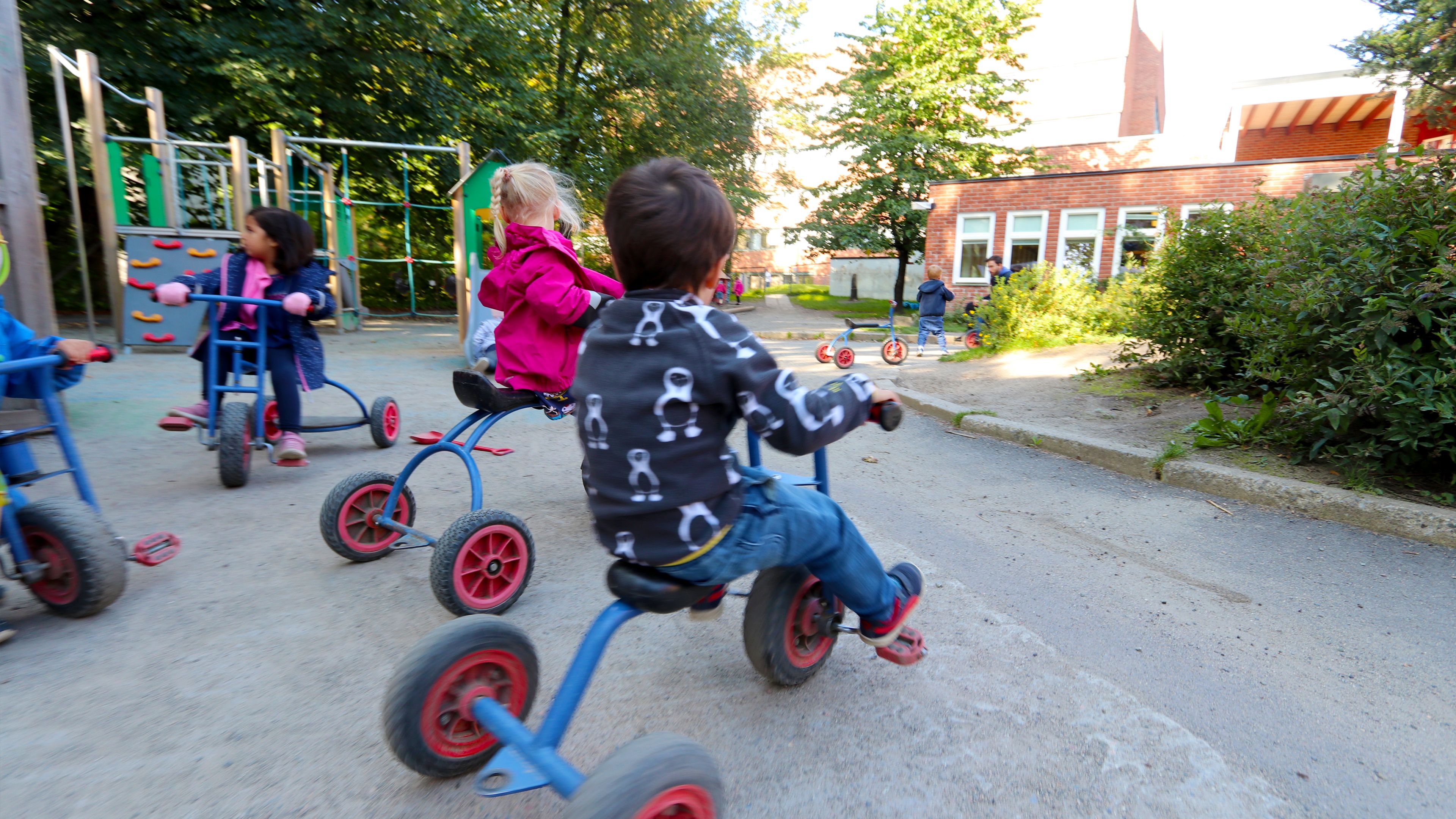 Fire barn som sykler på blå barnesykler