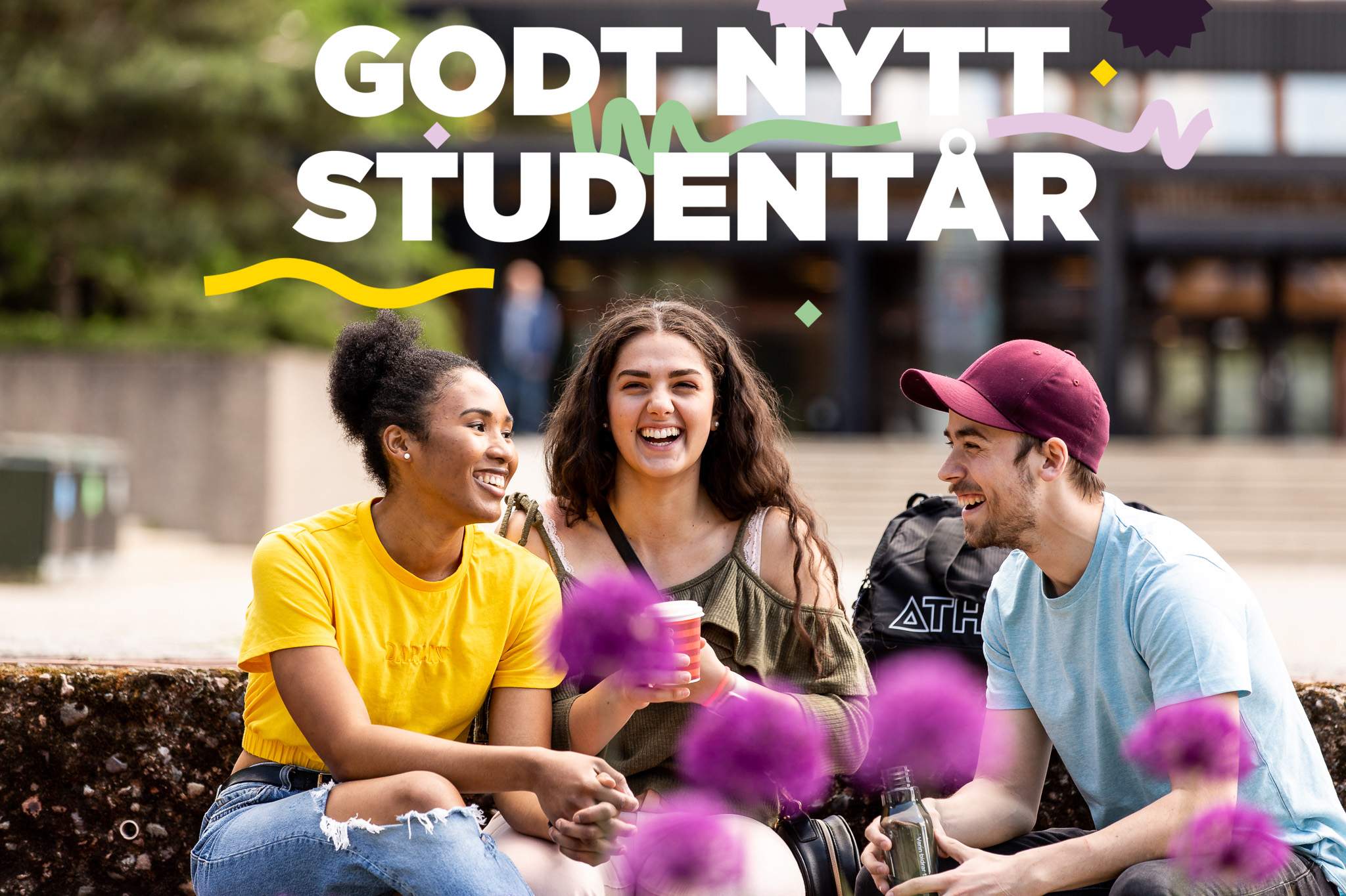 Foto av tre studenter som smiler og snakker sammen.
