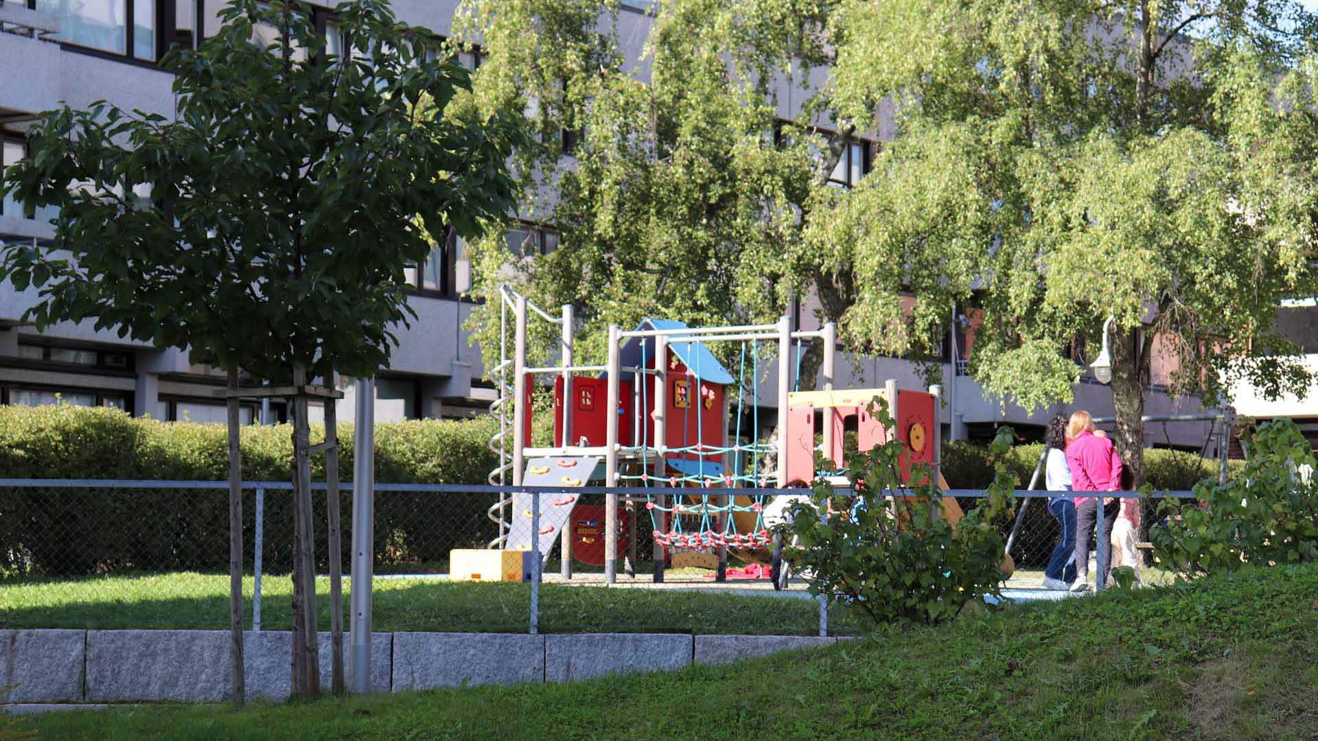 Foto av barnehage på Kringsjå med grønt gress og grønne trær.