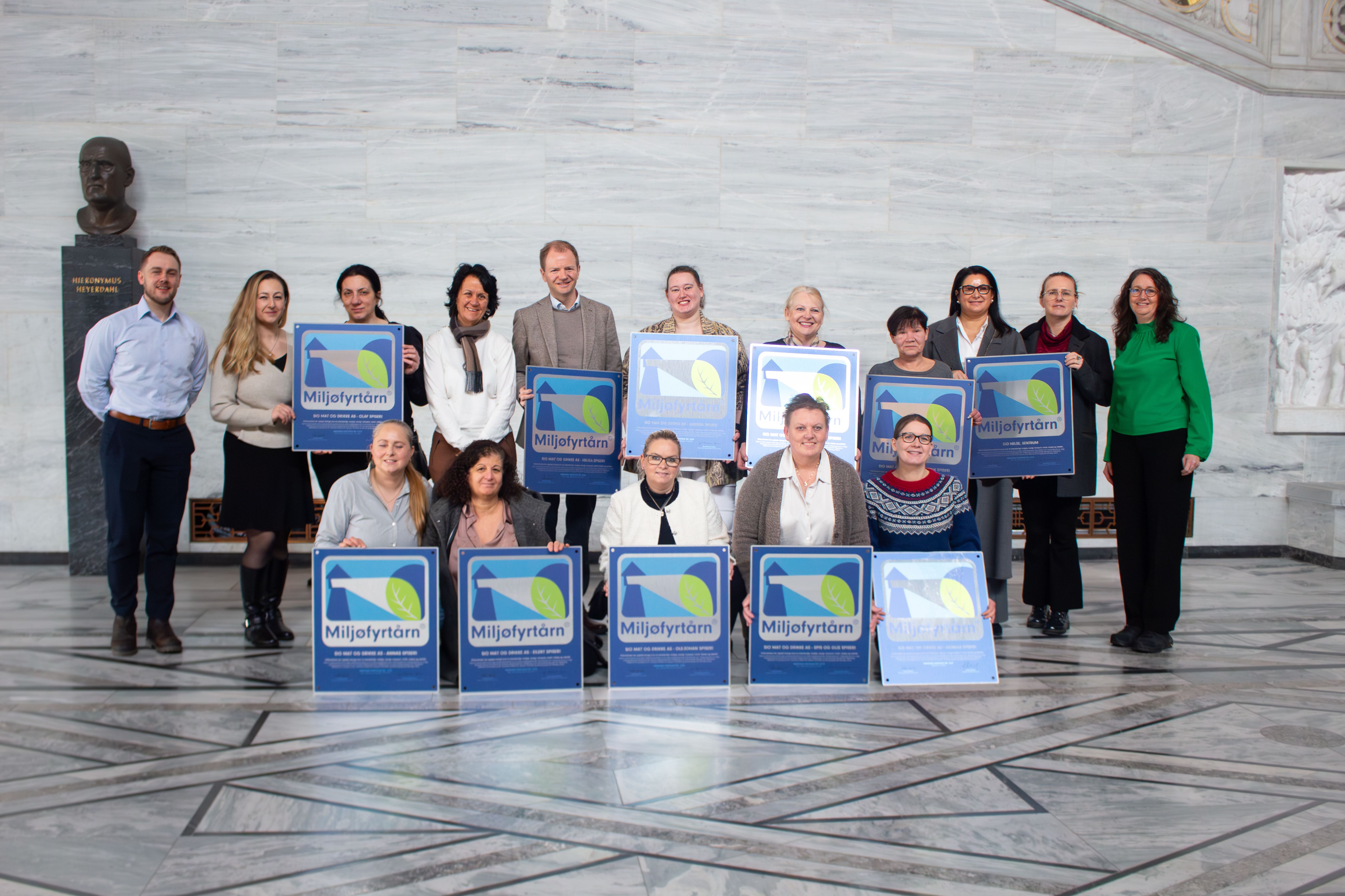 Bilde av en gruppe mennesker som holder plaketter med Miljøfyrtårn-sertifiseringer. 