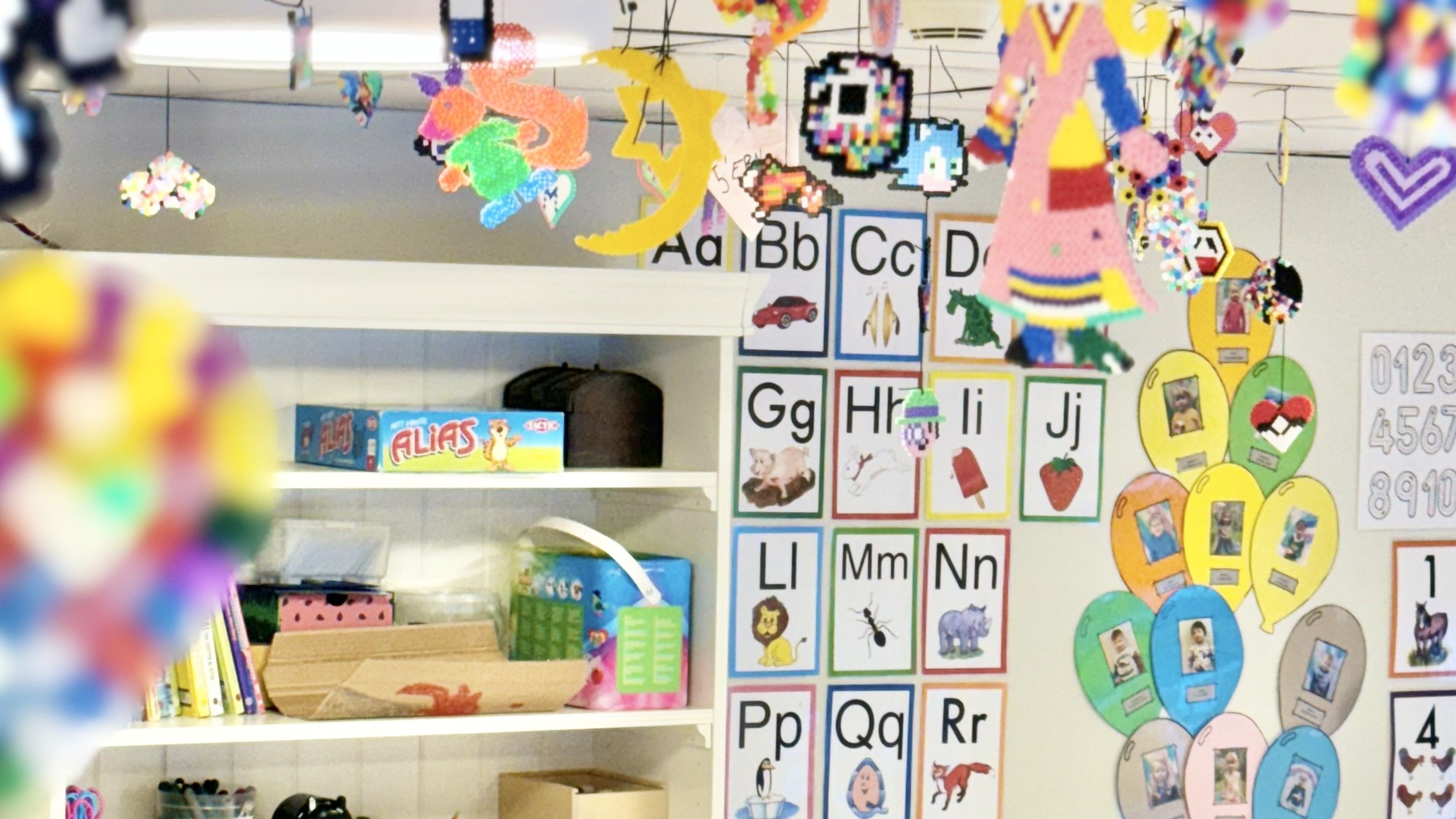 Bilde av vegg med bilder av bokstaver og et skap med leker som er fargerikt
